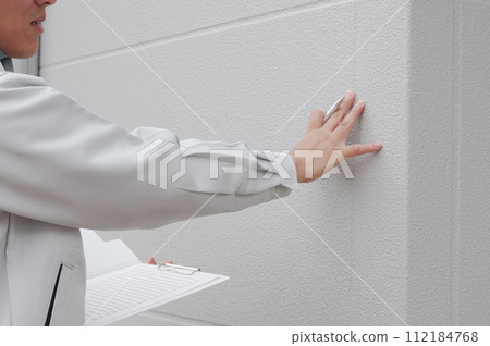 A worker checking the exterior wall 112184768
