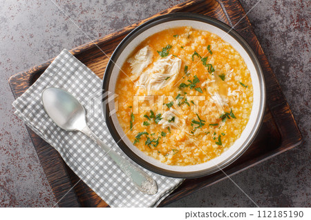 Homemade puree soup with pastina, chicken, vegetables and cheese close-up in a bowl. Horizontal top view 112185190