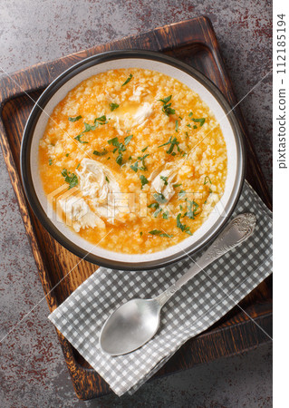 Homemade fresh hot chicken soup with Pastina close-up on a bowl. Vertical top view 112185194