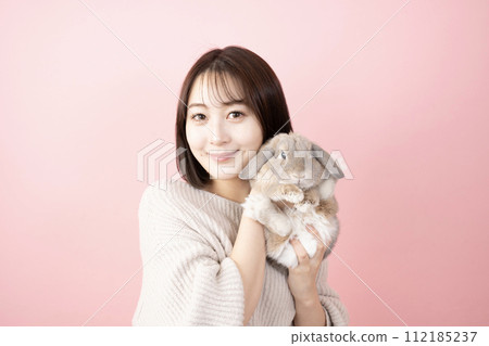 A smiling woman holding a rabbit A smiling woman holding a rabbit 112185237