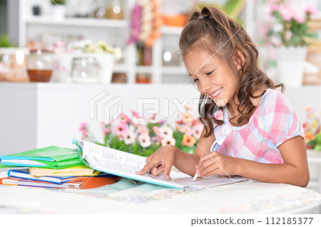 Portrait of happy schoolgirl studying at home 112185377