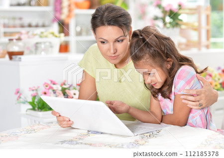 Portrait of happy mother and daughter using laptop 112185378