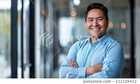 Portrait of a successful  businessman with confident and friendly facial expression and his arms crossed in front of blurred office background. Generative AI 112185412