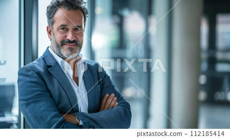 Portrait of a successful  businessman with confident and friendly facial expression and his arms crossed in front of blurred office background. Generative AI 112185414