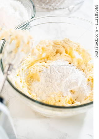 Skillfully combine ingredients using a hand mixer to prepare a rich, smooth cream cheese buttercream frosting, which is perfect for adorning the bundt cake. Skillfully combine ingredients using a hand mixer to prepare a rich, smooth cream cheese buttercream frosting, which is perfect for adorning the bundt cake. 112185669