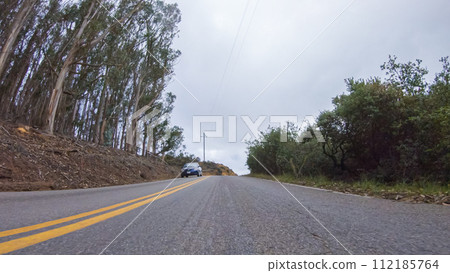 In this serene winter scene, a vehicle carefully makes its way along Los Osos Valley Road and Pecho Valley Road within Montana de Oro State Park. In this serene winter scene, a vehicle carefully makes its way along Los Osos Valley Road and Pecho Valley Road within Montana de Oro State Park. 112185764