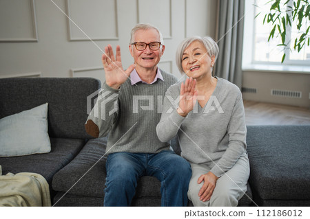 Happy senior woman man talk on video call with friends family. Mature old grandmother grandfather talking speaking with grown up children online. Older generation modern tech usage. Webcamera view Happy senior woman man talk on video call with friends family. Mature old grandmother grandfather talking speaking with grown up children online. Older generation modern tech usage. Webcamera view 112186012