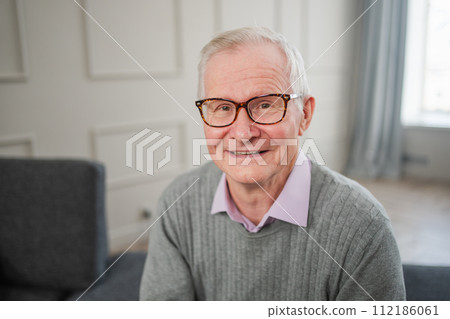 Portrait of confident stylish European middle aged senior man at home. Older mature 70s man smiling. Happy attractive senior grandfather looking camera close up face headshot portrait. Happy people Portrait of confident stylish European middle aged senior man at home. Older mature 70s man smiling. Happy attractive senior grandfather looking camera close up face headshot portrait. Happy people 112186061