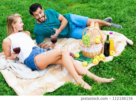 Couple are talking and drinking wine in time picnic outdoor Couple are talking and drinking wine in time picnic outdoor 112186156