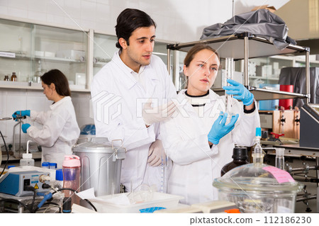 Chemists analyzing liquid samples 112186230