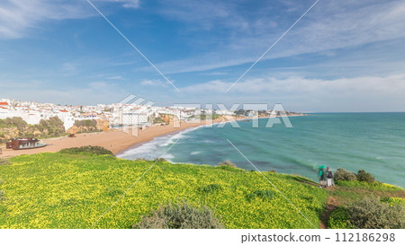 Wide sandy beach and Atlantic ocean in city of Albufeira timelapse. Algarve, Portugal Wide sandy beach and Atlantic ocean in city of Albufeira timelapse. Algarve, Portugal 112186298