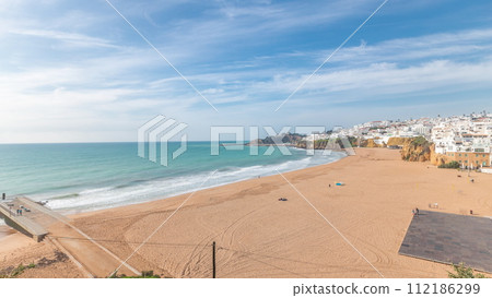 Wide sandy beach and Atlantic ocean in city of Albufeira timelapse. Algarve, Portugal Wide sandy beach and Atlantic ocean in city of Albufeira timelapse. Algarve, Portugal 112186299
