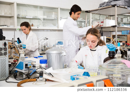 Woman lab technician writing report on chemical experiments Woman lab technician writing report on chemical experiments 112186336