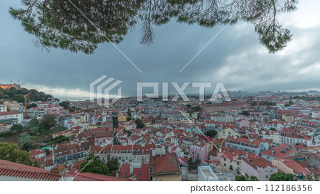 Panorama showing aerial cityscape day to night transition from Miradouro da Graca viewing point in Lisbon city after sunset Panorama showing aerial cityscape day to night transition from Miradouro da Graca viewing point in Lisbon city after sunset 112186356