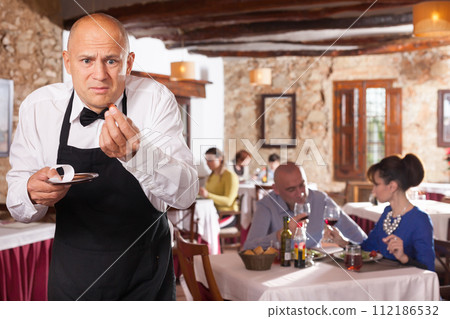 Waiter expressing displeasure with small tips 112186532