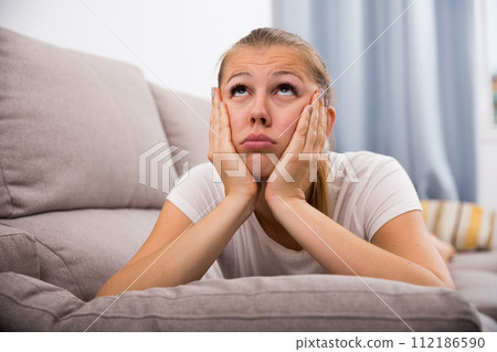 Sad woman is propped her cheeks with hands because she bored Sad woman is propped her cheeks with hands because she bored 112186590