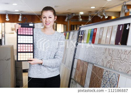 woman standing with sample of ceramic tile 112186887