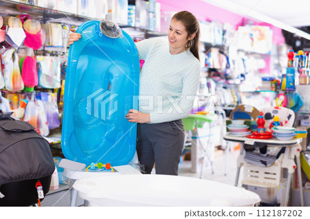 Pregnant woman is choosing baby bath in the shop. Pregnant woman is choosing baby bath in the shop. 112187202