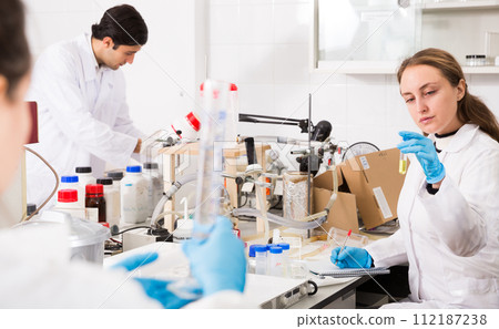 Female chemist writing results of experiments 112187238