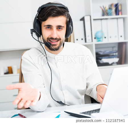 Man with earphones working at office Man with earphones working at office 112187341