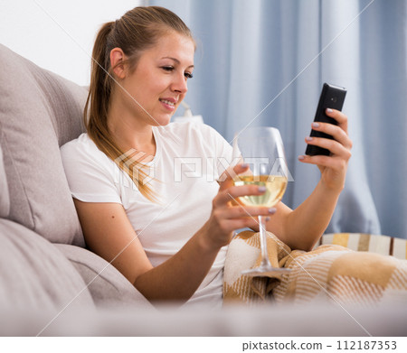 Young female with modern mobile and wine Young female with modern mobile and wine 112187353