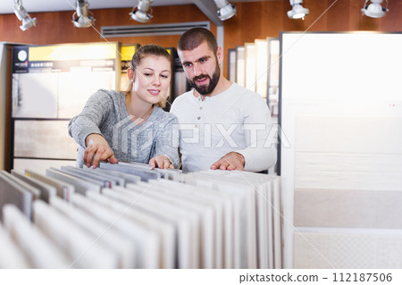 couple looking laminated flooring couple looking laminated flooring 112187506