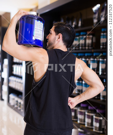 Athletic young man showing biceps 112187520