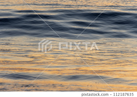 waves illuminated by the sunrise 112187635