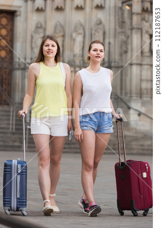 female tourists exploring old european city with baggage female tourists exploring old european city with baggage 112187653