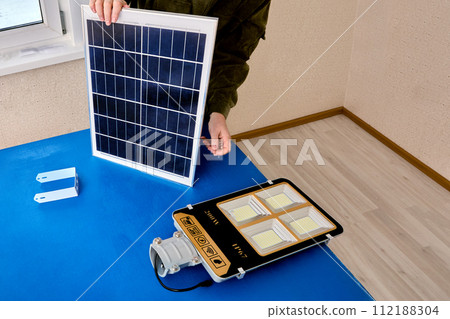 Solar panel for LED outdoor lighting, assembler mounts street light to bracket. 112188304