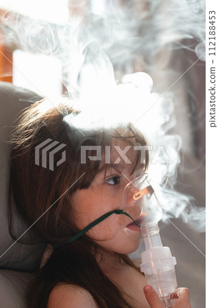 Calm child girl using nebuliser mask Calm child girl using nebuliser mask 112188453