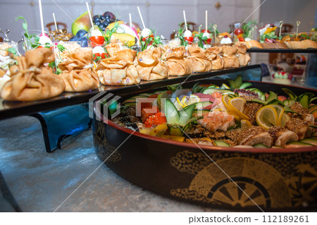A buffet in a chic hotel with seafood, sushi, salads, fruits and pastries. 112189261
