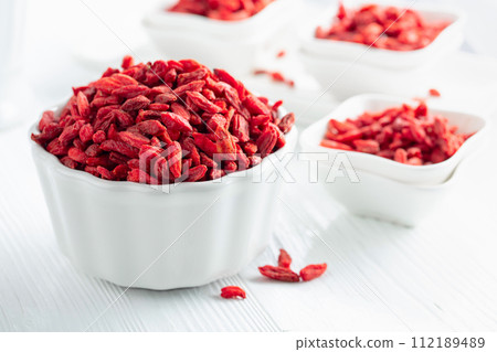 Dried goji berries on a white table. Dried goji berries on a white table. 112189489