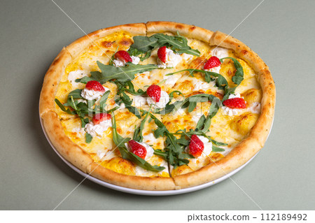 Freshly Baked Pizza with Strawberries, Cream Cheese, and Arugula on White Plate - Summer Party Theme Freshly Baked Pizza with Strawberries, Cream Cheese, and Arugula on White Plate - Summer Party Theme 112189492