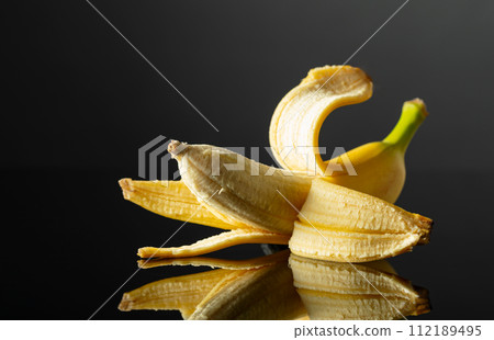 Banana on a black reflective background. 112189495
