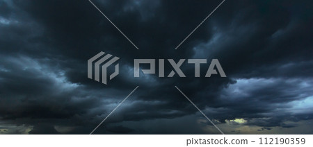 The dark sky with heavy clouds converging and a violent storm before the rain.Bad or moody weather sky and environment. carbon dioxide emissions, greenhouse effect, global warming, climate change. 112190359