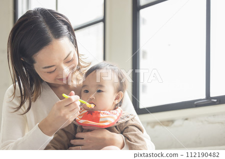 Mother who makes baby eat baby food 112190482