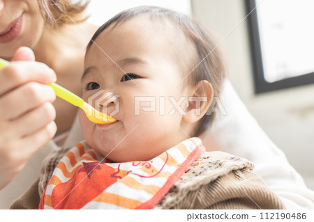 Baby eating baby food 112190486