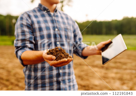 Gardening or ecology concept. Farmer's hands collects soil and checks its health before growing crop Gardening or ecology concept. Farmer's hands collects soil and checks its health before growing crop 112191843
