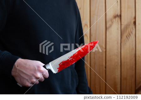 Killer holds bloody knife in hand 112192009