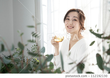 Beauty Woman holding a tea cup by the window Beauty Woman holding a tea cup by the window 112192130