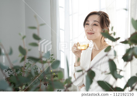 Beauty Woman holding a tea cup by the window Beauty Woman holding a tea cup by the window 112192150
