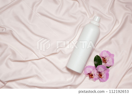 Floral scented laundry detergent on satin fabric top view, copy space for text Floral scented laundry detergent on satin fabric top view, copy space for text 112192653