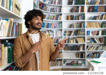 A person stands in a library, surrounded by shelves lined with books. Their posture and finger pointing gesture suggest they are confident, possibly in the middle of giving an explanation or 112193136