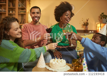 Portrait of adult Black woman clinking glasses with friends and enjoying Birthday party celebration at home Portrait of adult Black woman clinking glasses with friends and enjoying Birthday party celebration at home 112193418
