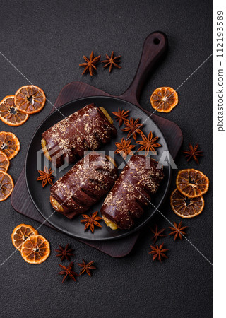 Delicious sweet chocolate cakes with fruit filling and sprinkles on a ceramic plate Delicious sweet chocolate cakes with fruit filling and sprinkles on a ceramic plate 112193589