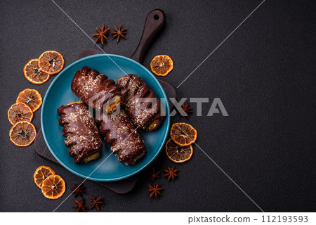 Delicious sweet chocolate cakes with fruit filling and sprinkles on a ceramic plate Delicious sweet chocolate cakes with fruit filling and sprinkles on a ceramic plate 112193593