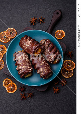 Delicious sweet chocolate cakes with fruit filling and sprinkles on a ceramic plate 112193596