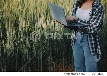 Smart farm. Farmer with tablet in the field. Agriculture, gardening or ecology concept. Harvesting. Agro business. 112193602