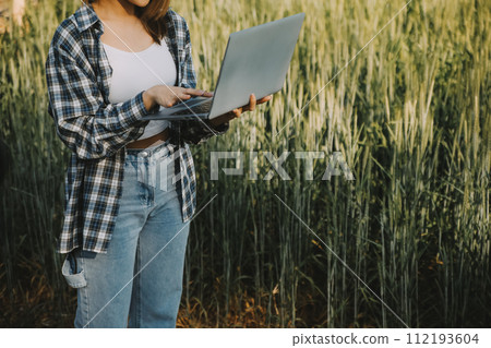 Smart farm. Farmer with tablet in the field. Agriculture, gardening or ecology concept. Harvesting. Agro business. 112193604